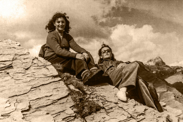 Le due ragazze, sedute sulle rocce montuose, si riposano dopo la salita